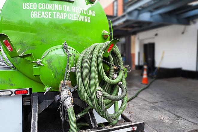 grease trap being pumped out by service technician in Beverly Hills